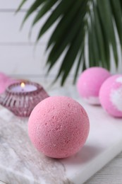 Photo of Beautiful aromatic bath bombs on white wooden table, closeup. Space for text