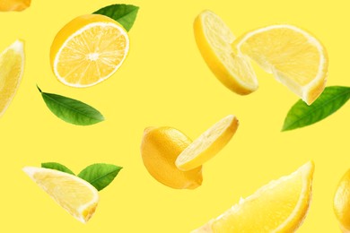 Image of Fresh ripe lemons and green leaves flying on yellow background