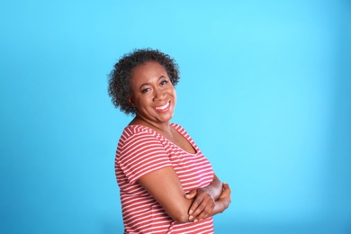 Photo of Portrait of happy African-American woman on light blue background