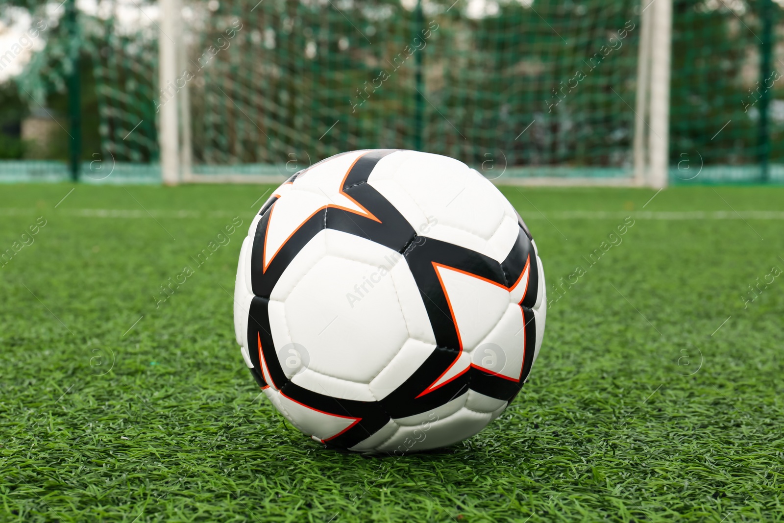 Photo of New soccer ball on green football field