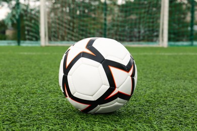 New soccer ball on green football field