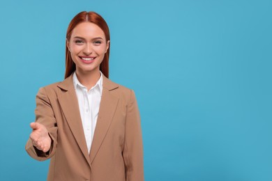 Photo of Happy woman welcoming and offering handshake on light blue background, space for text