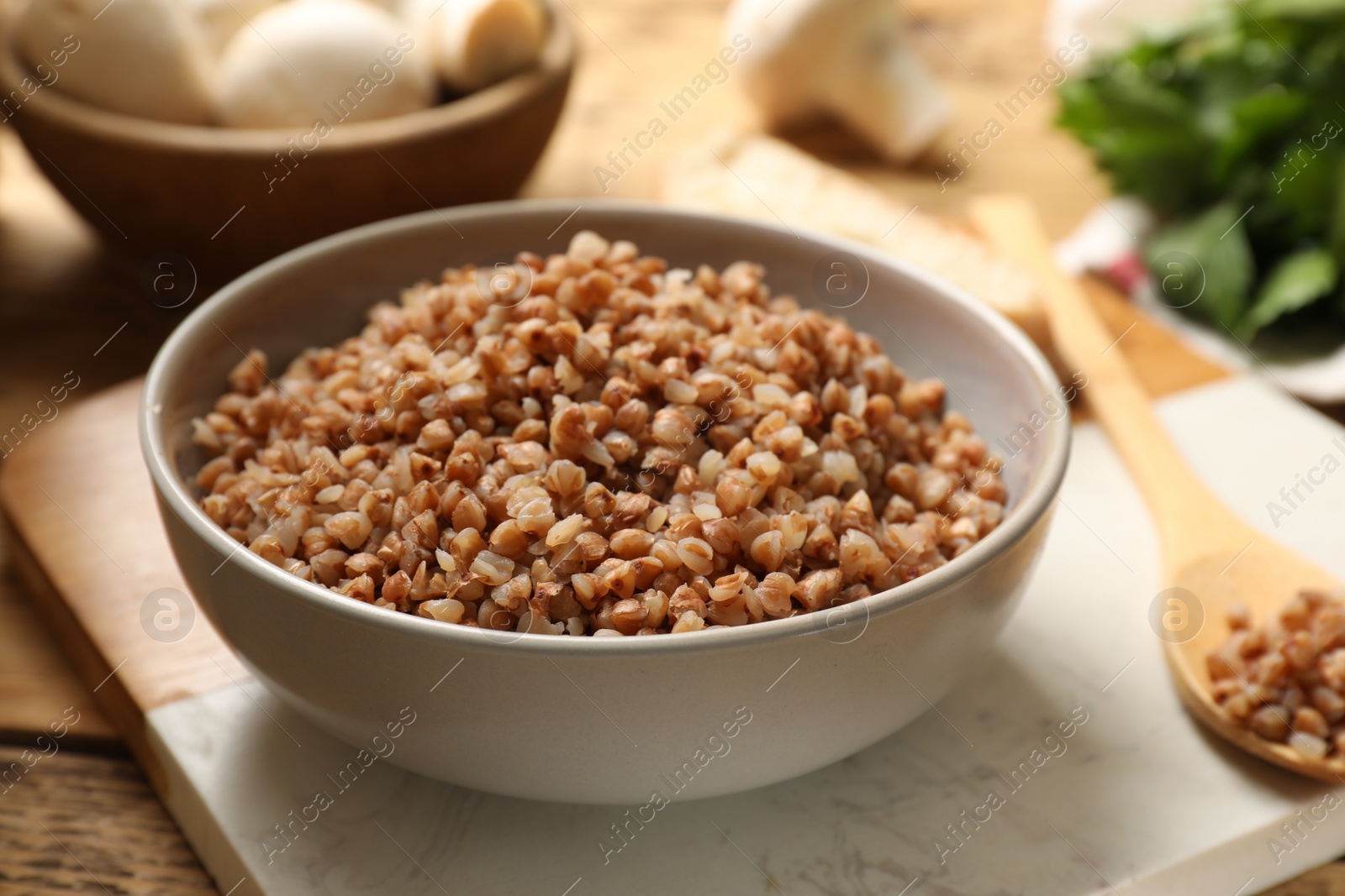 Photo of Tasty buckwheat in bowl served on wooden table, closeup