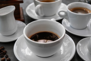 Photo of Cups of fresh aromatic coffee on grey background