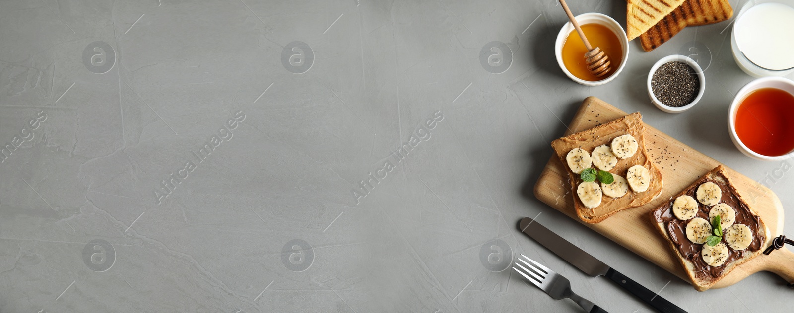 Image of Tasty bruschettas with banana and chia seeds served on table, top view. Space for text, banner design 