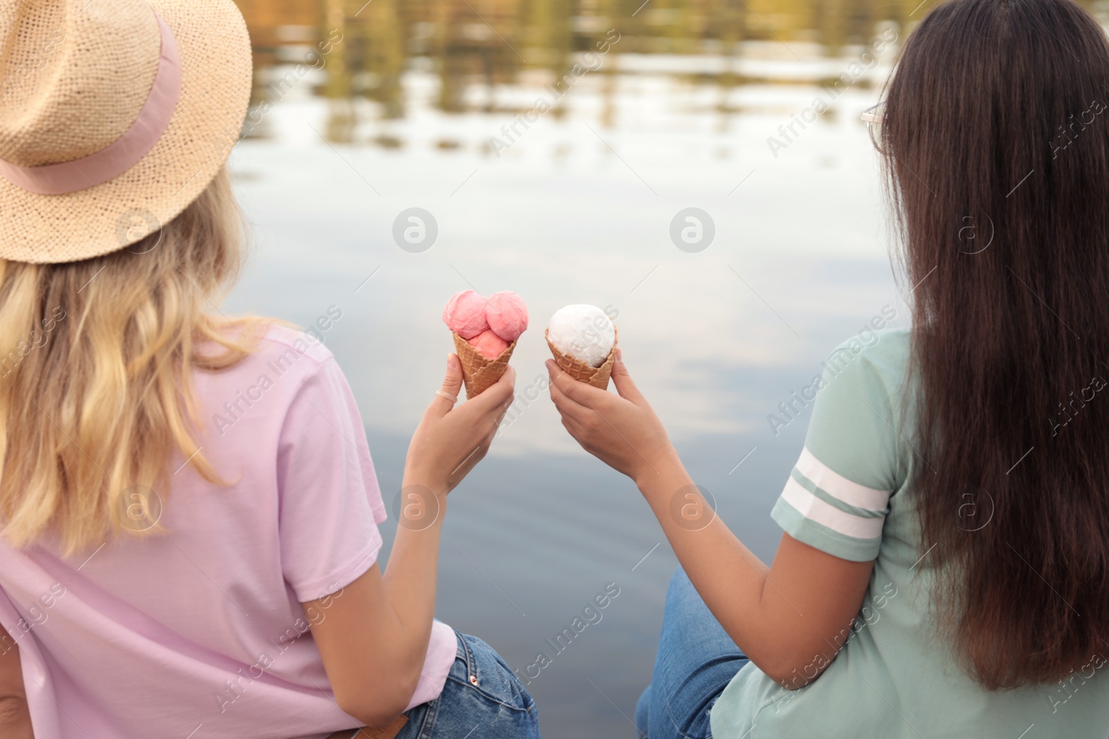 Photo of Young women with ice cream spending time together outdoors