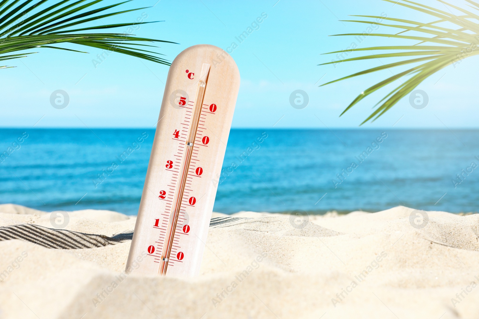 Image of Weather thermometer with high temperature on sandy beach near sea