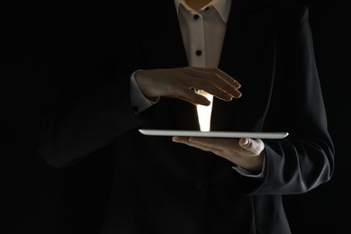 Photo of Closeup view of man using modern tablet on black background