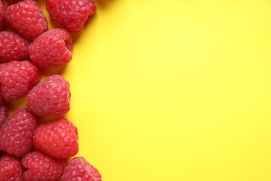 Photo of Fresh sweet ripe raspberries on yellow background, flat lay. Space for text