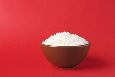 Photo of Bowl of boiled rice on color background