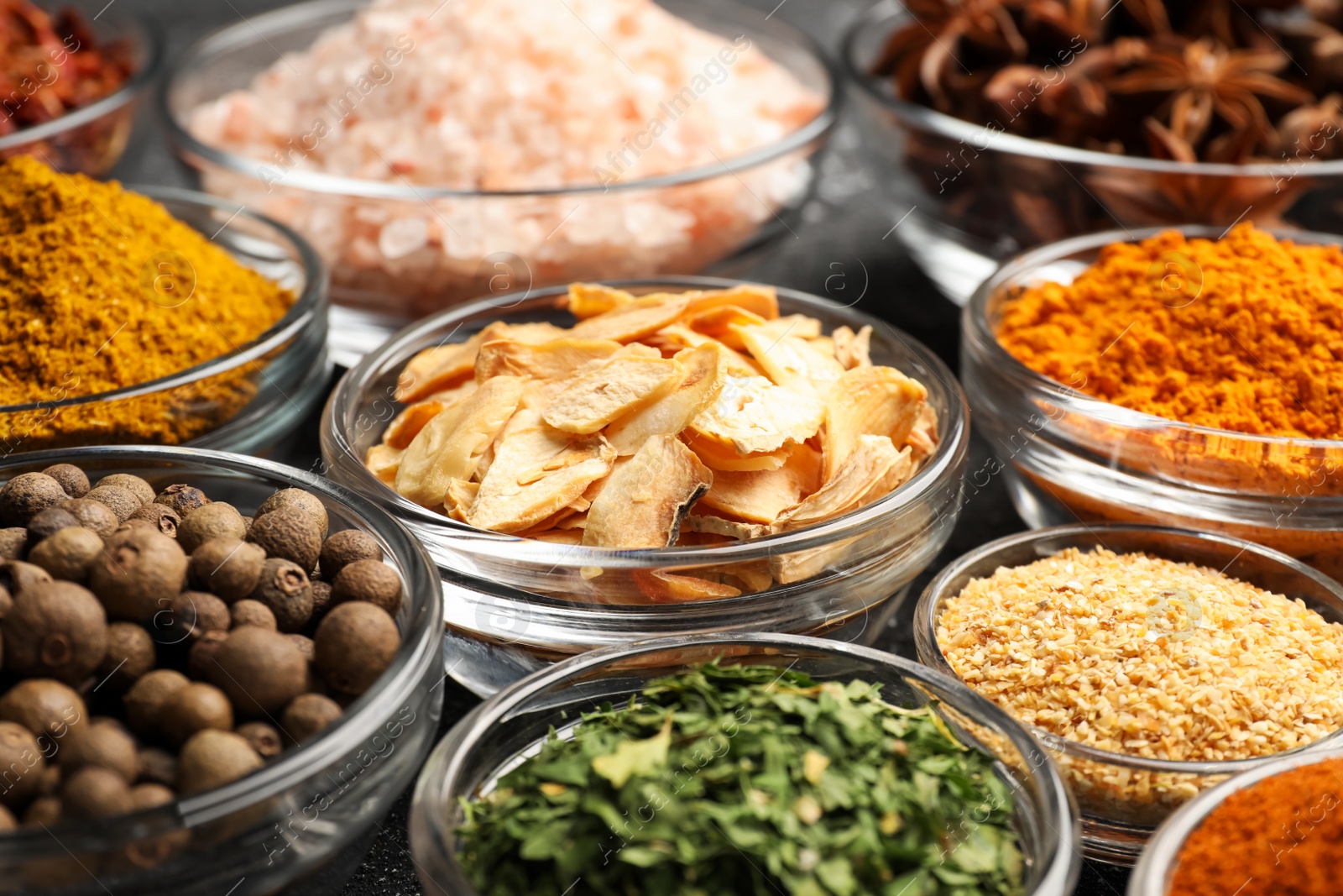 Photo of Glass bowls with different spices, closeup view