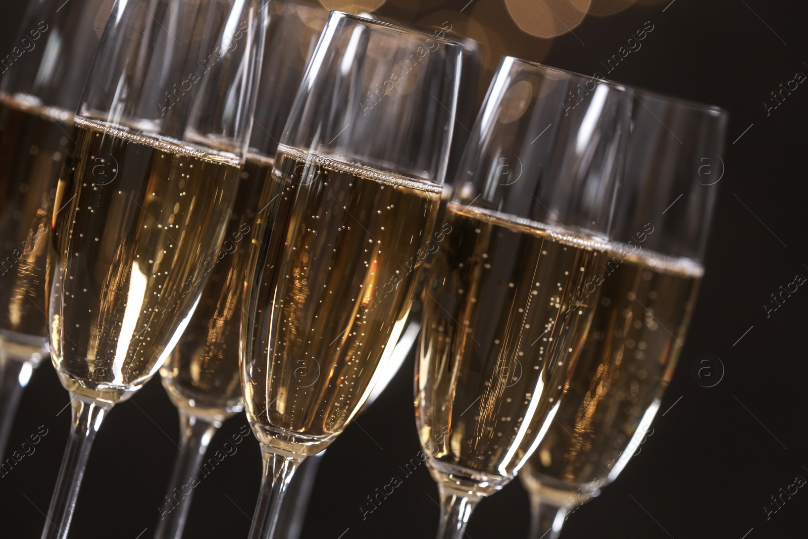 Photo of Many glasses of champagne on blurred background, closeup