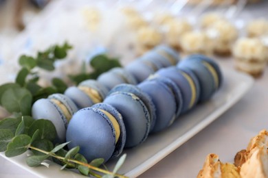 Delicious sweet macarons served on table, closeup