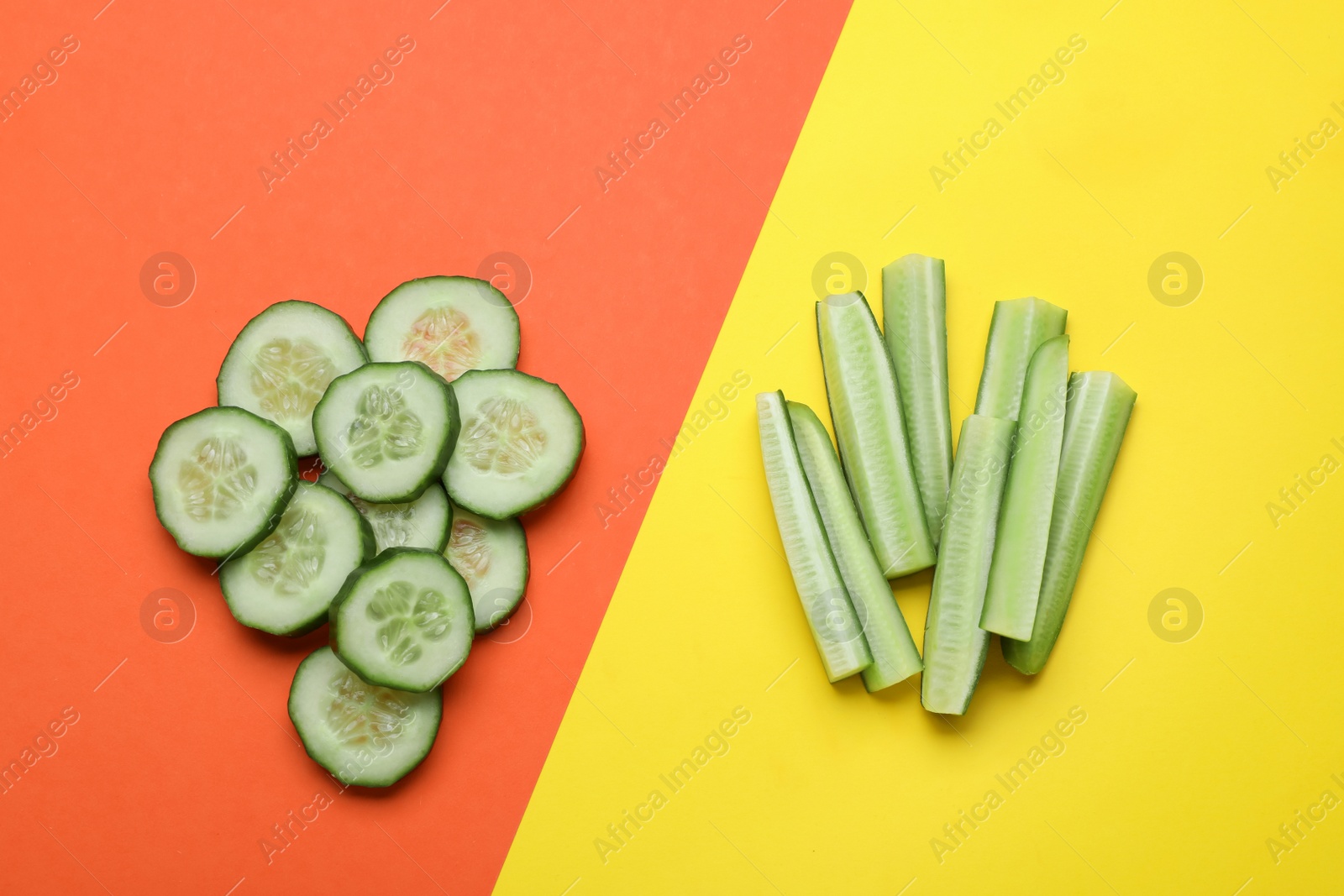 Photo of Cut fresh ripe cucumbers on color background, flat lay