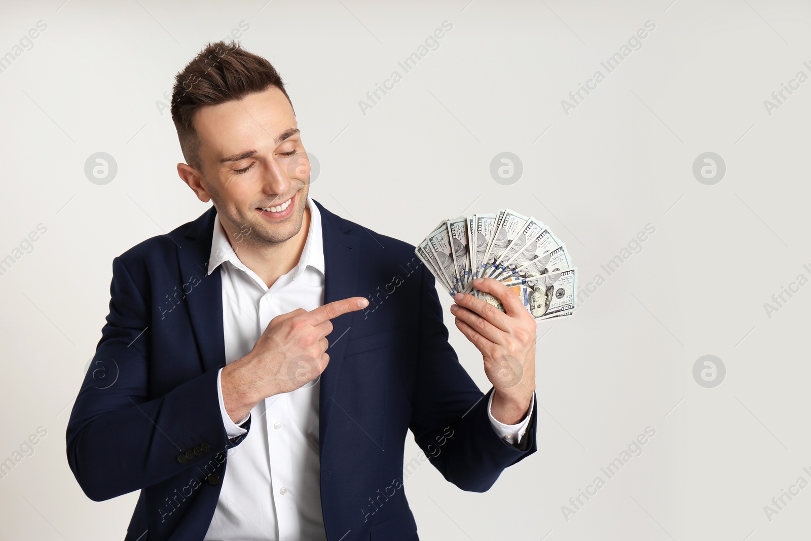 Photo of Happy man with cash money on light grey background