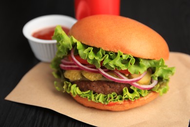 Photo of One tasty burger on wooden table, closeup