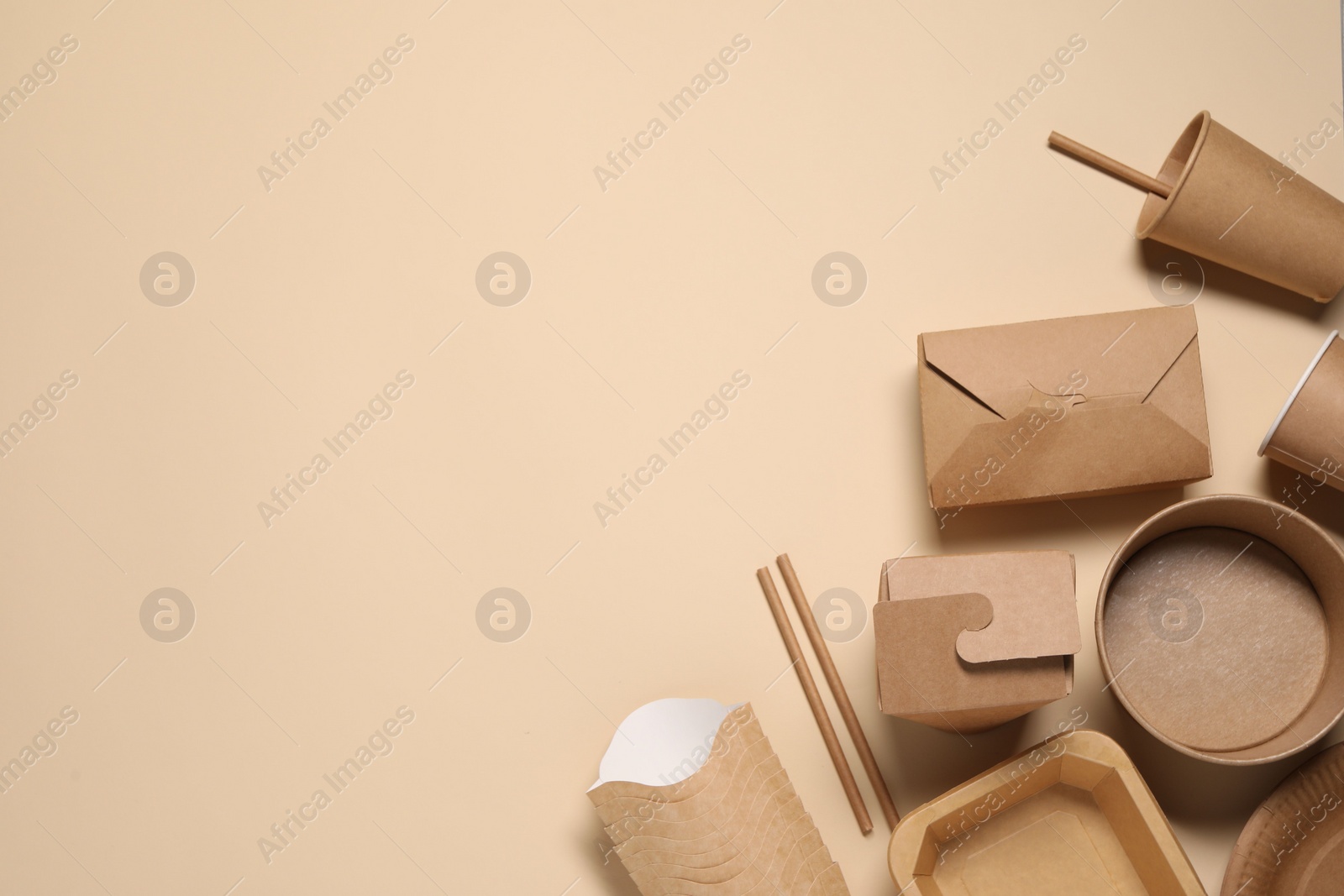 Photo of Eco friendly food packaging. Different paper containers on beige background, flat lay. Space for text