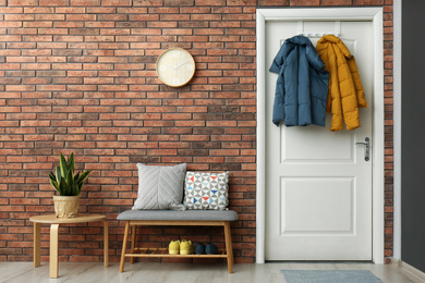 Photo of Hallway interior with stylish furniture, clothes and accessories