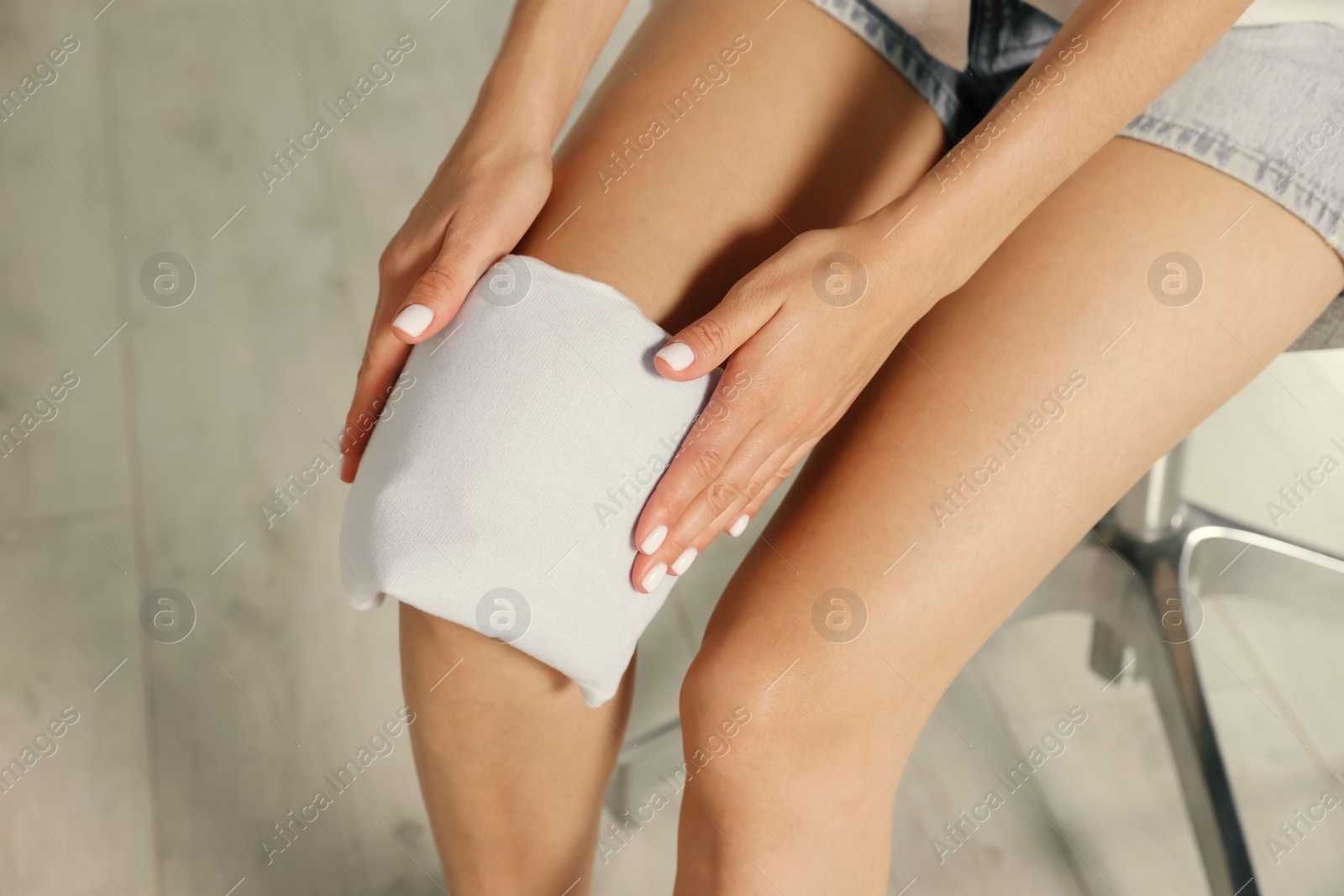 Photo of Woman using heating pad at home, closeup