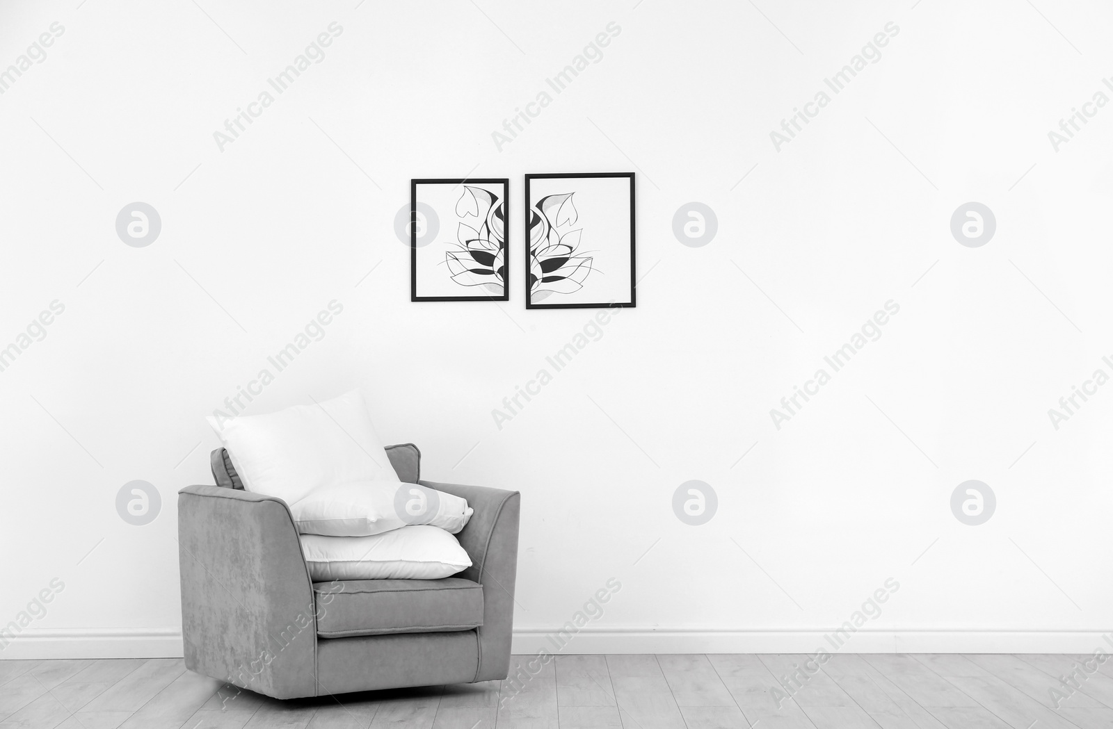 Photo of Pile of soft bed pillows on armchair near white wall with space for text