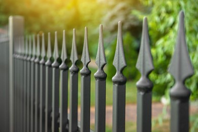 Photo of Railing of beautiful black iron fence outdoors, closeup