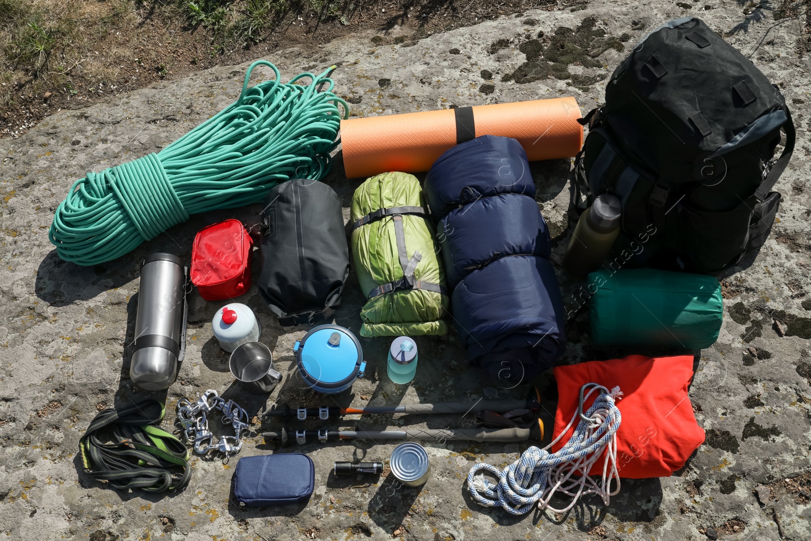 Photo of Backpack with hiking equipment on rock outdoors, above view