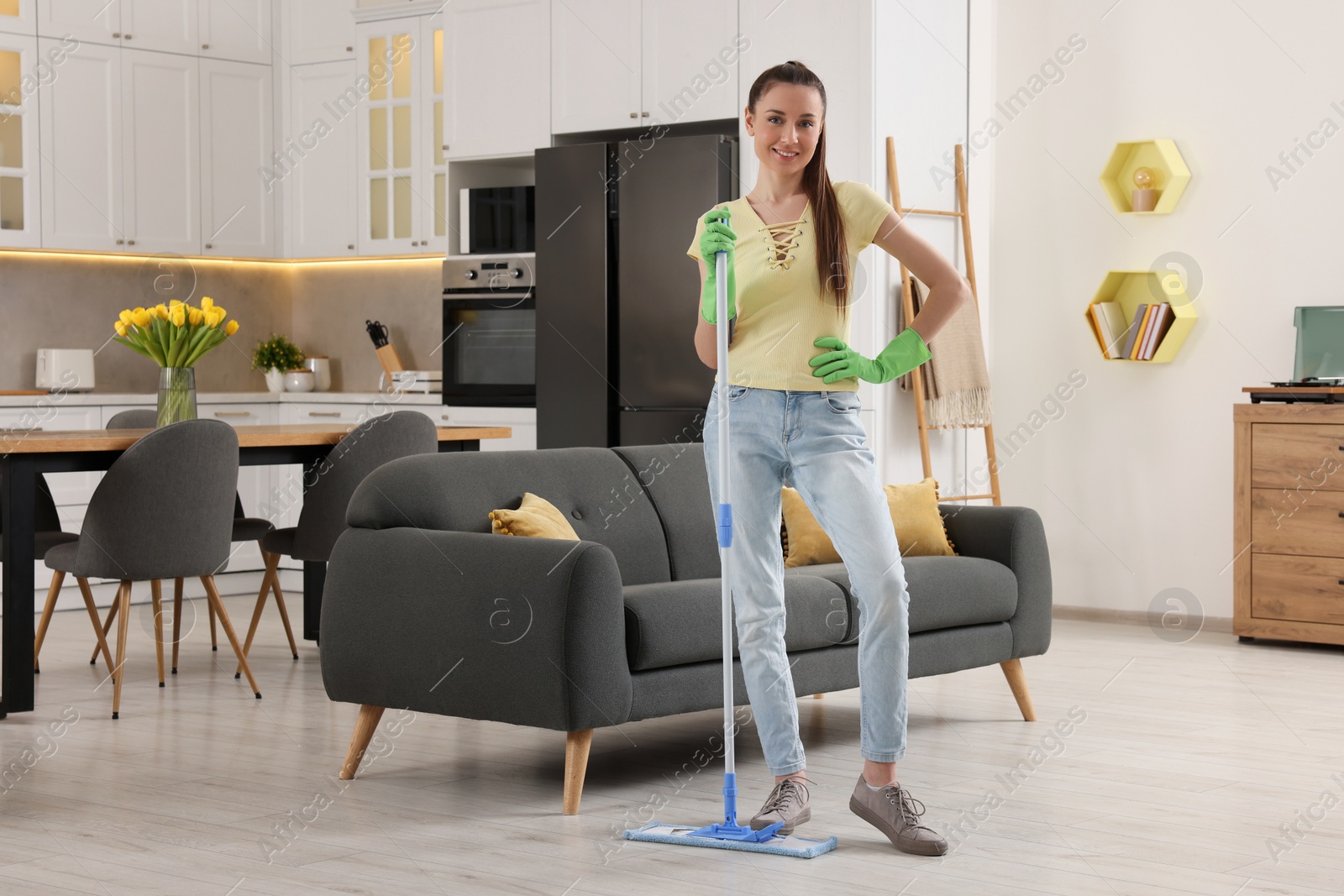 Photo of Spring cleaning. Young woman with mop washing floor at home