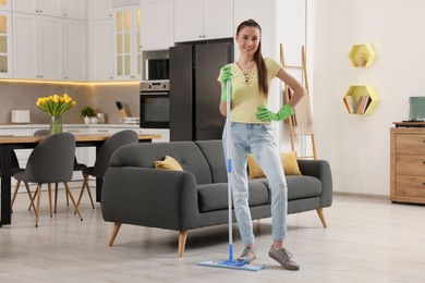 Spring cleaning. Young woman with mop washing floor at home