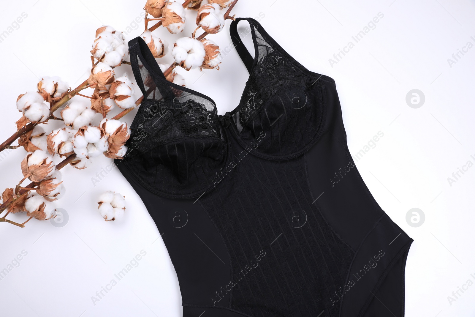 Photo of Elegant plus size black women's underwear and cotton flowers on white background, top view