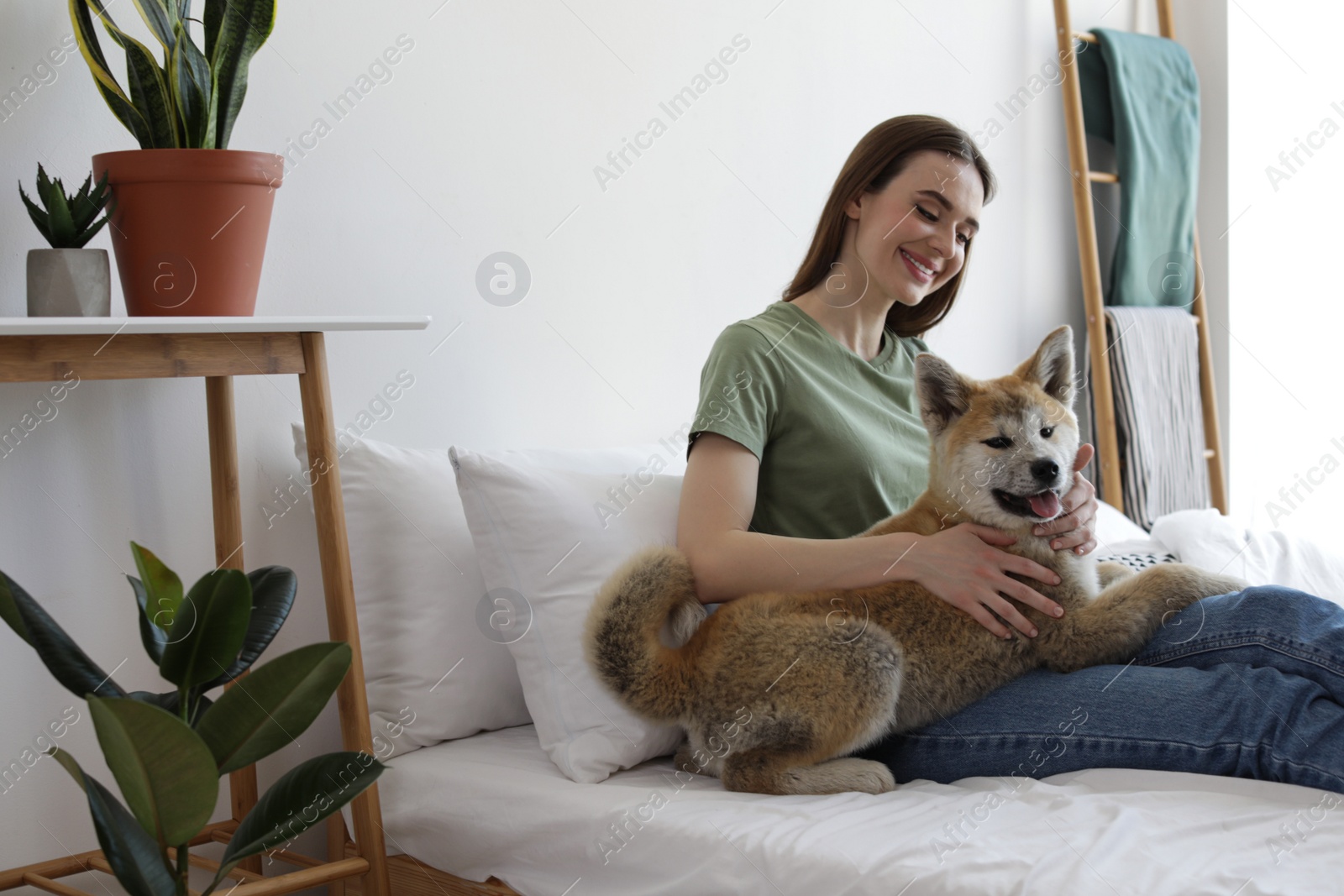 Image of Happy woman with her cute Akita Inu puppy at home