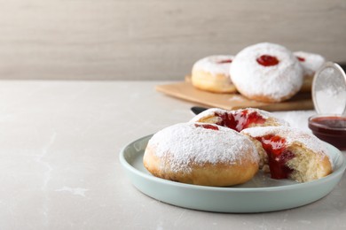 Delicious donuts with jelly and powdered sugar on light grey table. Space for text