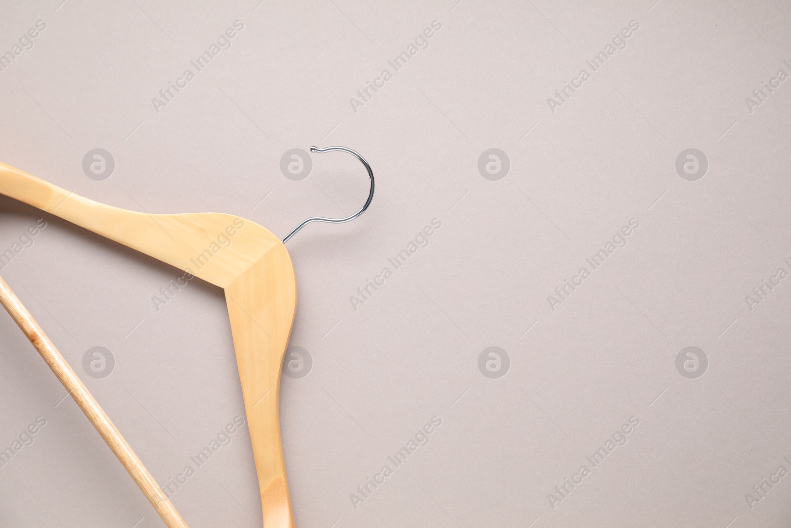 Photo of Empty wooden hanger on light grey background, top view. Space for text
