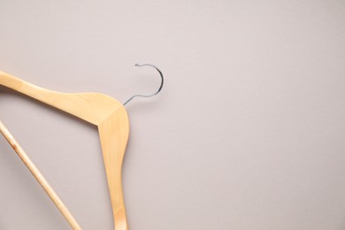 Empty wooden hanger on light grey background, top view. Space for text