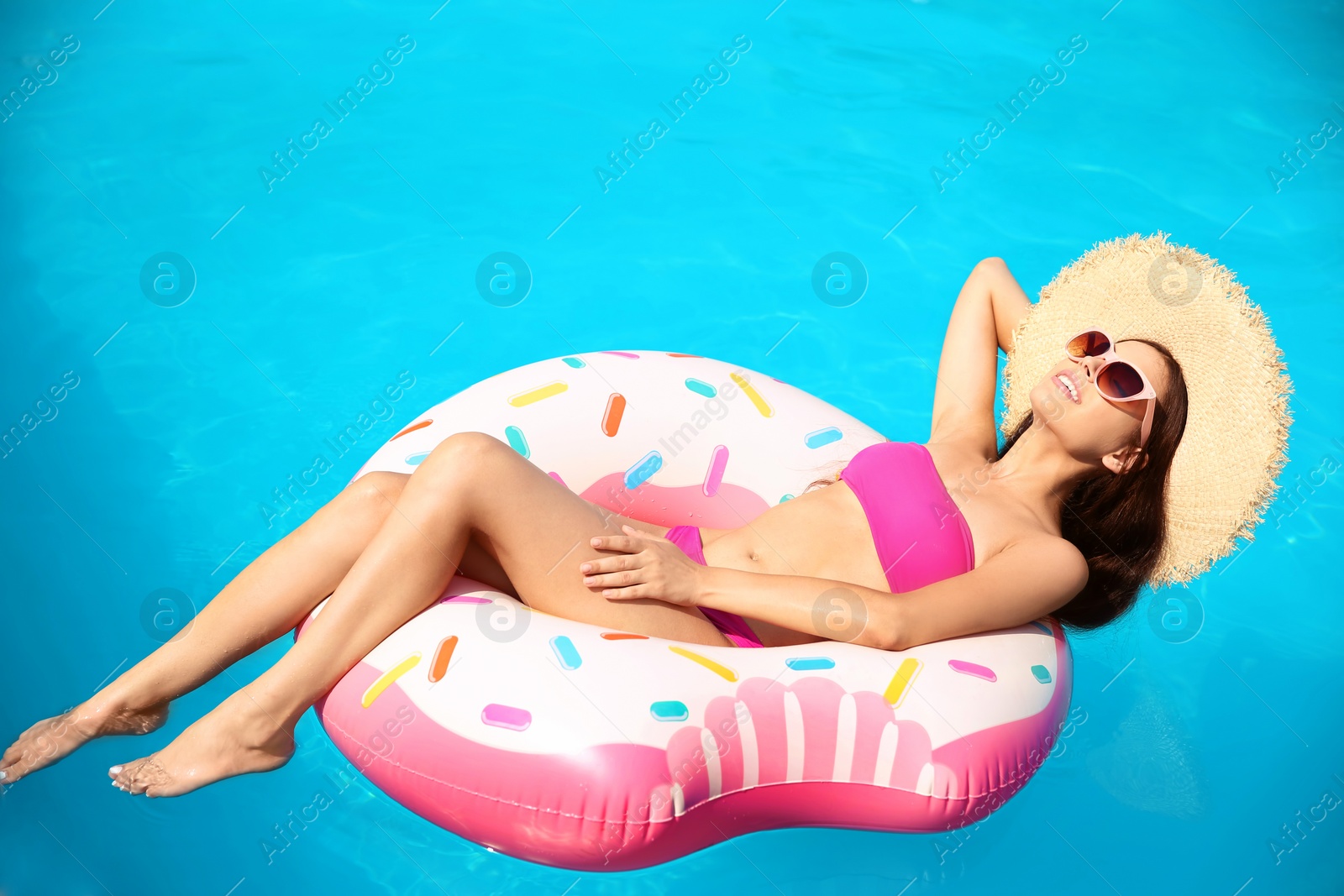 Photo of Beautiful young woman with inflatable ring in swimming pool
