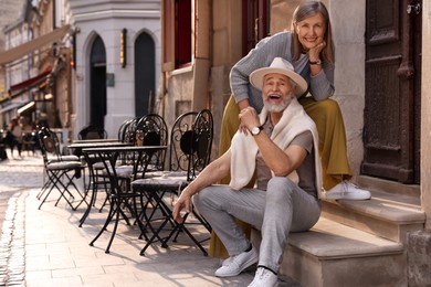 Photo of Smiling affectionate senior couple outdoors, space for text
