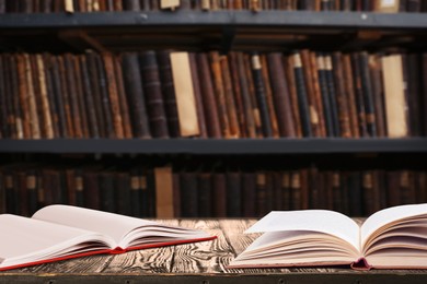 Open books on wooden table in library