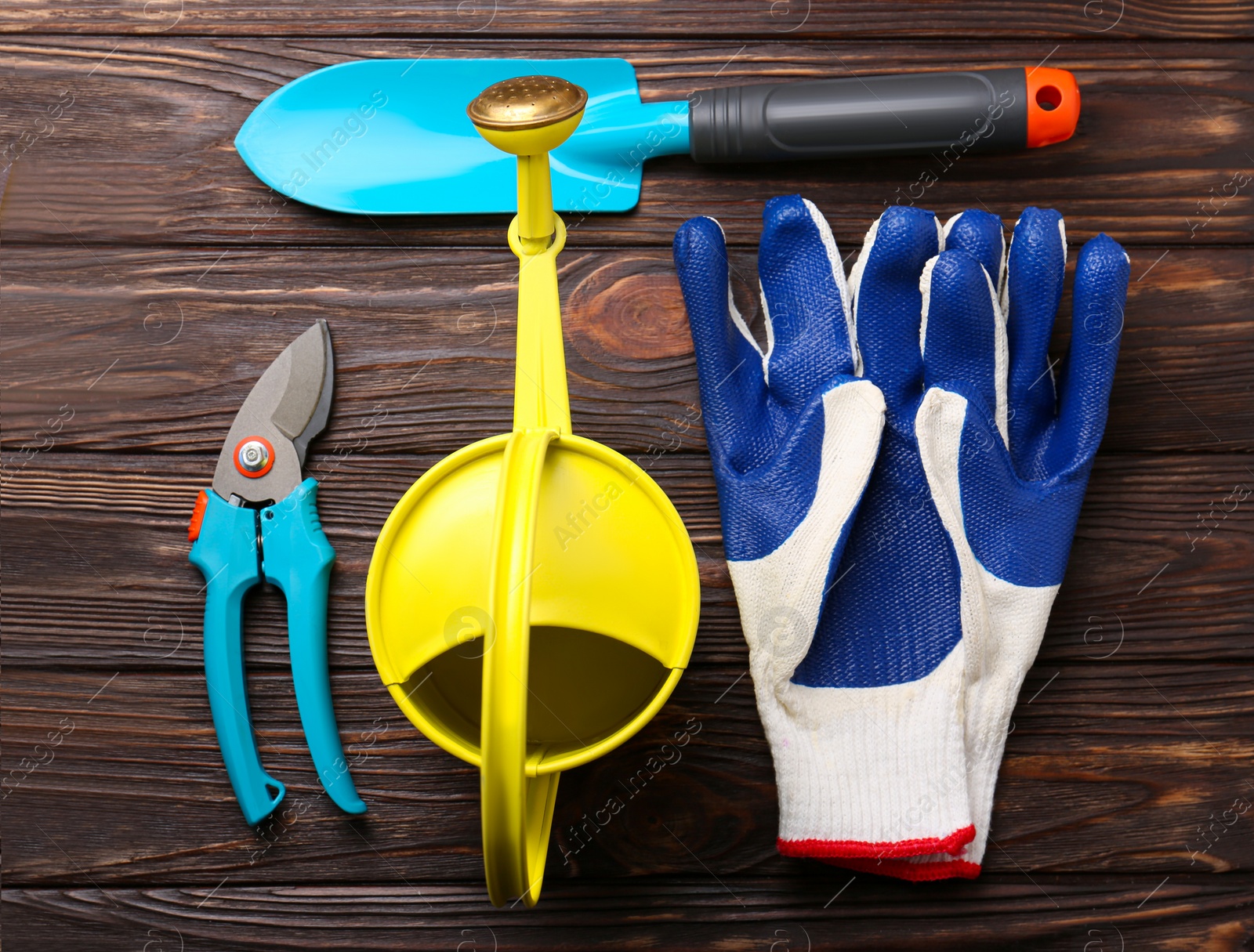 Photo of Flat lay composition with watering can and gardening tools on wooden table