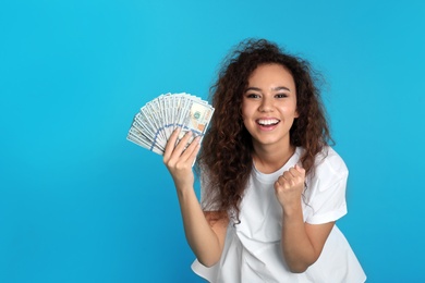 Photo of Young African-American woman with money on color background. Space for text