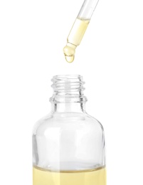 Photo of Dropping herbal essential oil into bottle isolated on white