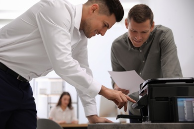 Employees using new modern printer in office