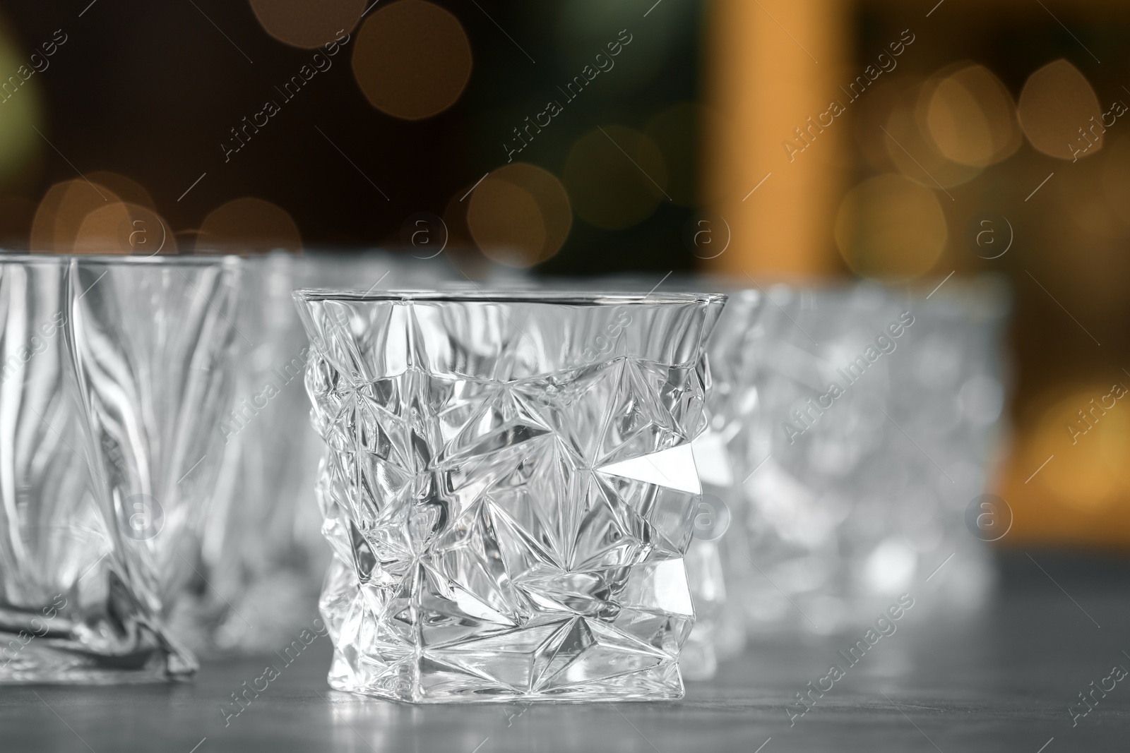 Photo of Empty glasses on table against blurred background