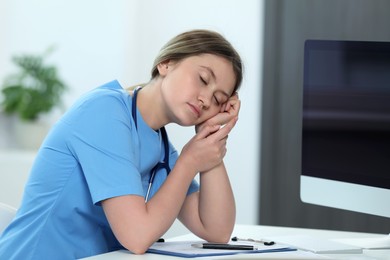 Exhausted doctor sleeping at workplace in hospital