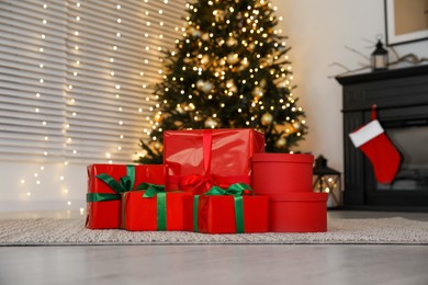 Photo of Beautifully wrapped gift boxes under Christmas tree indoors