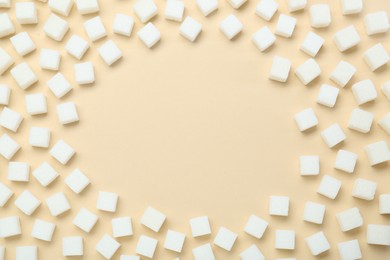 Photo of Frame made of white sugar cubes on beige background, top view. Space for text