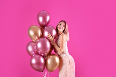 Photo of Young woman with air balloons on color background