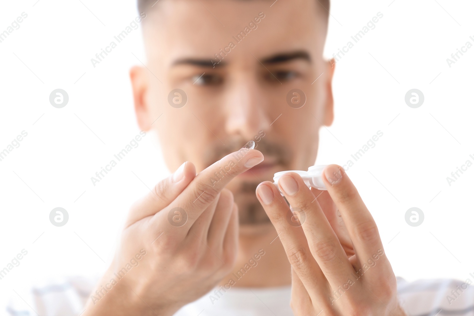 Photo of Young man with contact lens on light background