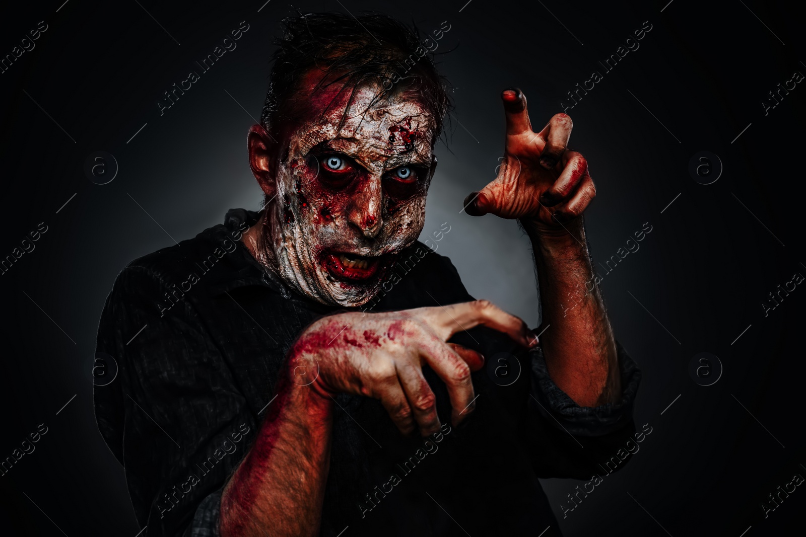 Photo of Scary zombie on dark background. Halloween monster