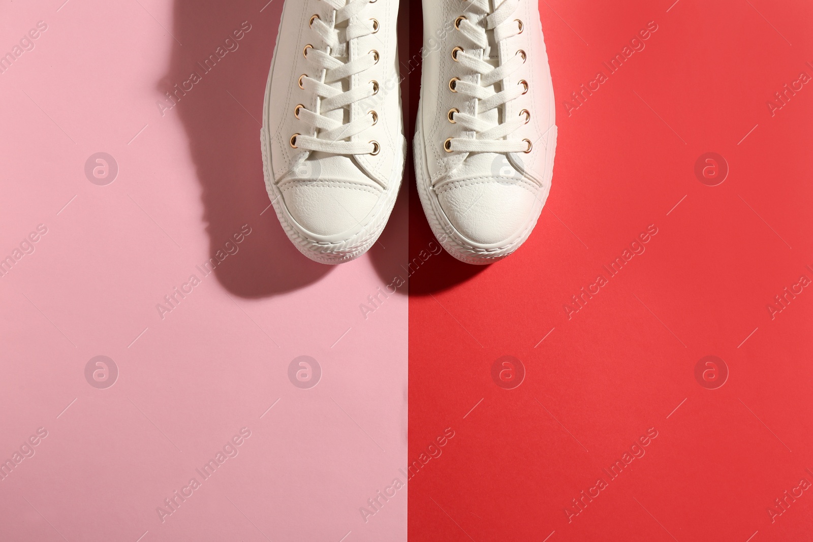 Photo of Pair of stylish sneakers on color background, top view with space for text