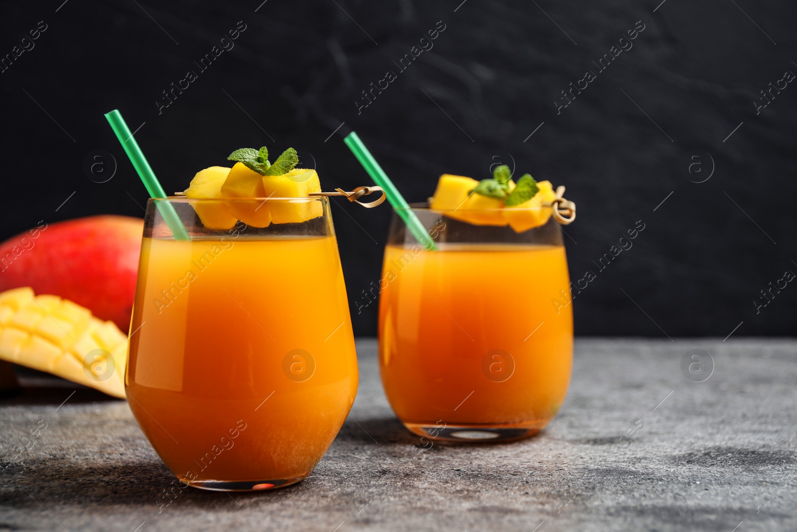 Photo of Fresh delicious mango drink on grey table