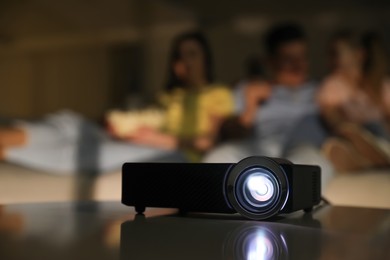 Photo of Family watching movie at night, focus on video projector